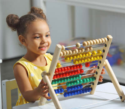 a little girl playing with abacus